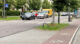 Auf dem Foto ist rechts ein Bürgersteig mit Radweg zu sehen. Links daneben ist eine Straße, auf der Autos fahren und parken und an der entlang Bäume gepflanzt sind.